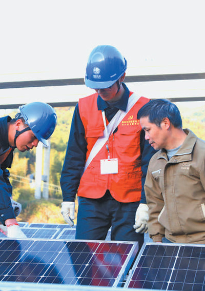 国网福建省电力公司员工帮助用户检查光伏发电板。郑 极摄.jpg